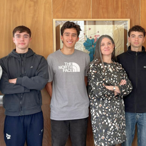 Equipo de seis personas frente a mapa en oficina de Decanato College, mostrando colaboración y ambiente profesional.