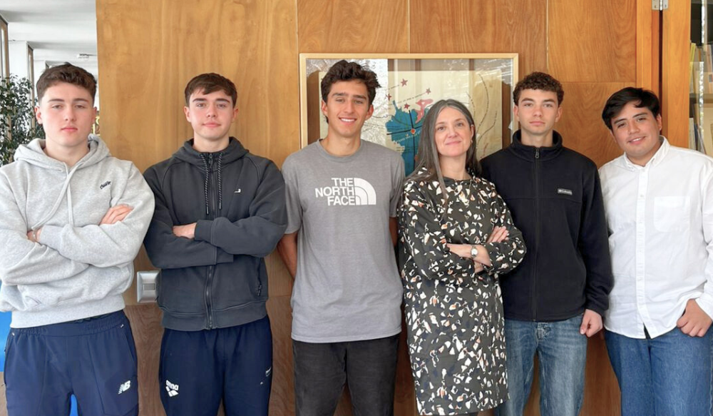 Equipo de seis personas frente a mapa en oficina, mostrando colaboración y ambiente profesional.