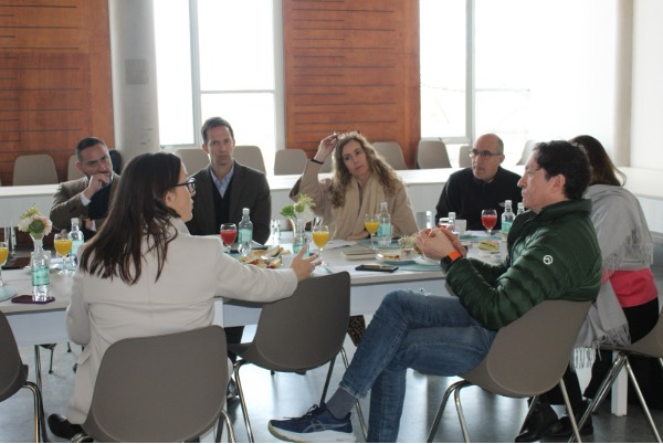 Reunión de negocios con equipo en mesa redonda, compartiendo ideas y estrategias corporativas.