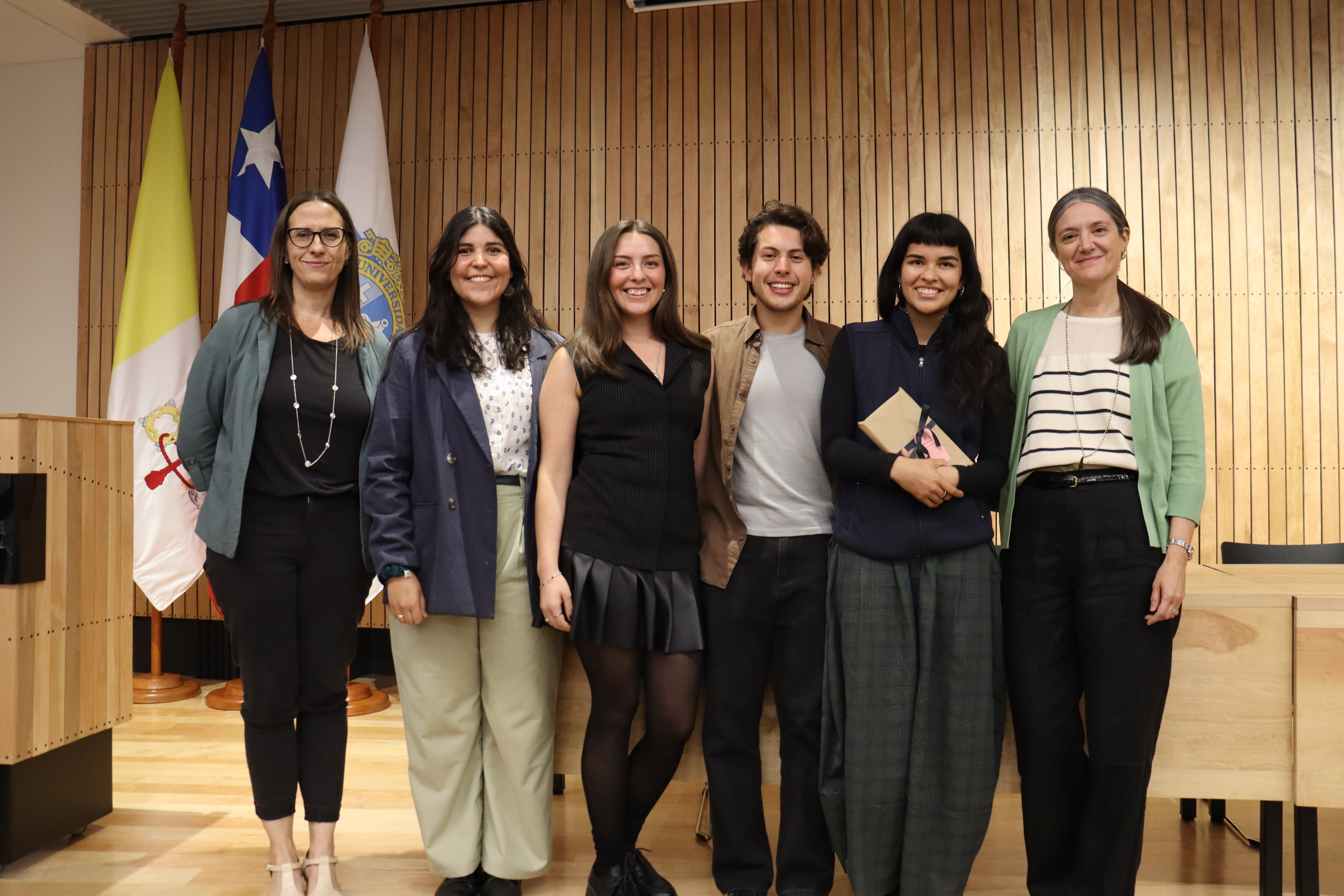 Los estudiantes que realizaron el documental sonríen en conjunto a autoridades de College UC.