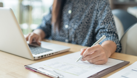 persona trabajando en computador, plano de sus manos.